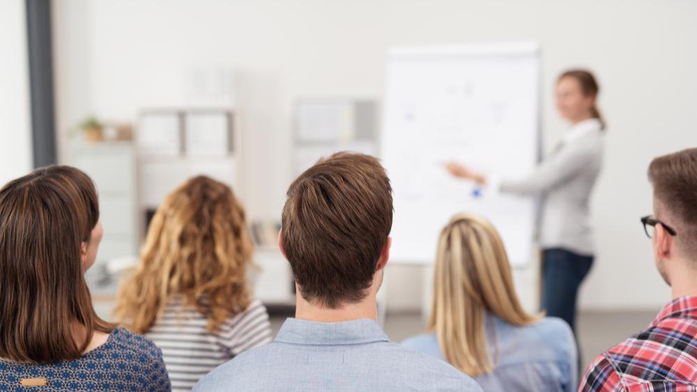 Profesora de MSMK explicando lecciones a estudiantes universitarios en clase